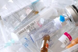 Medical syringes and ampoules of plastic and glass that were in use, waste, close-up