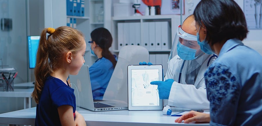 Pediatrician doctor with protection mask providing health care to woman with young child